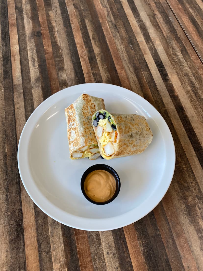 Breakfast burrito, halved, with chipotle mayo on the side